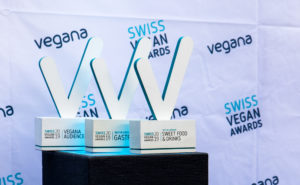 Drei Swiss Vegan Awards Trophäen auf einem Podium.